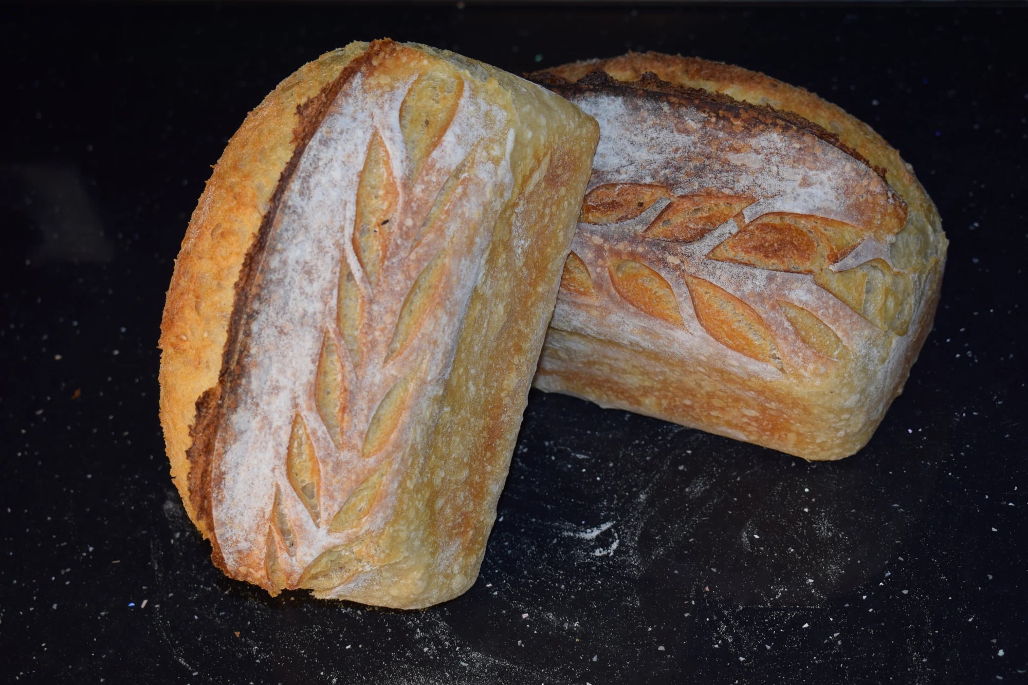 Sourdough white loaf scored in an ear-of-wheat pattern.