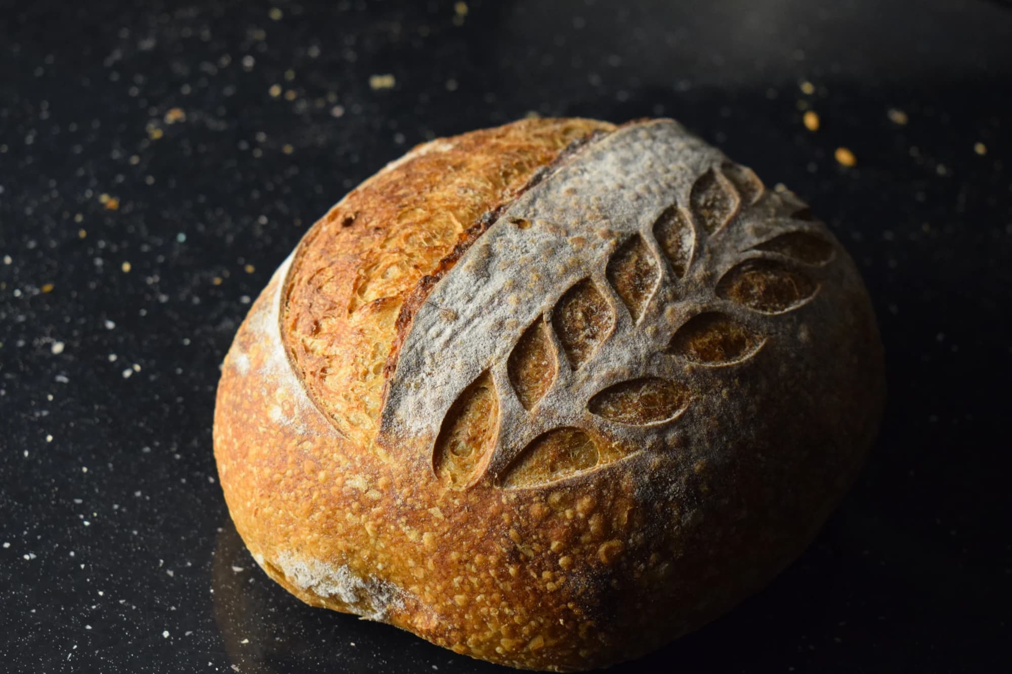 Round wholemeal loaf with an ear-of-wheat scored crust.